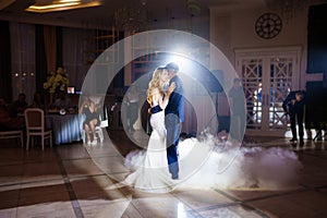 Beautiful and happy bride and groom dancing first dance at wedding.