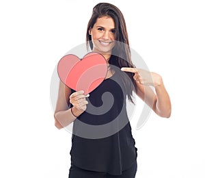 Beautiful happy brunette woman holding and showing a big red heart