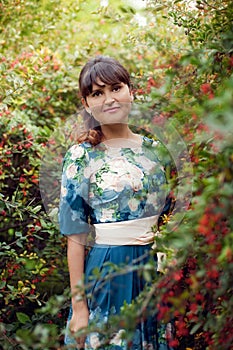 Beautiful happy brunette woman in the park on a warm summer day