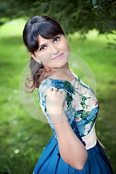 Beautiful happy brunette woman in the park on a warm summer day