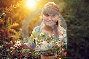 Beautiful happy brunette woman in the park on a warm summer day