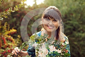 Beautiful happy brunette woman in the park on a warm summer day