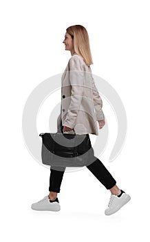 Beautiful happy businesswoman with briefcase walking on white background