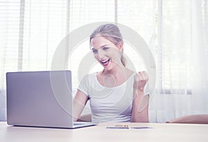 Beautiful happy caucasian woman in casual communicate via computer by video chat in living room.Work at home,stay at home and