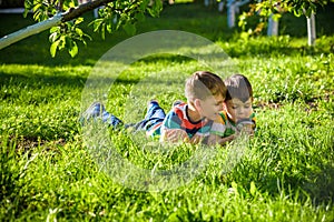 Beautiful happy children, boy brothers, exploring nature with magnifying glass, summertime