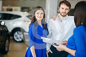 Beautiful happy couple standing near their new car