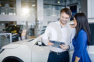 Beautiful happy couple standing near their new car