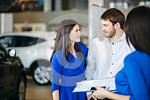 Beautiful happy couple standing near their new car