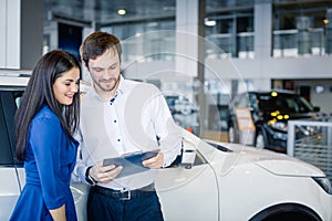 Beautiful happy couple standing near their new car