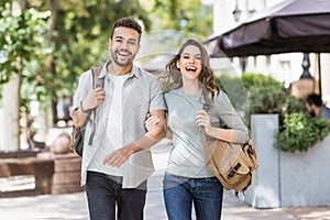 Beautiful happy couple summer portrait. Young joyful smiling woman and man in a city. Love, travel, tourism, students concept