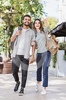 Beautiful happy couple summer portrait. Young joyful smiling woman and man in a city. Love, travel, tourism, students concept