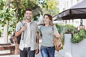 Beautiful happy couple summer portrait. Young joyful smiling woman and man walking in a city.