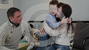 Beautiful and happy dad mom and son on the couch in a modern interior.