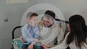 Beautiful and happy dad mom and son on the couch in a modern interior.