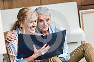 beautiful happy elderly couple looking at photo