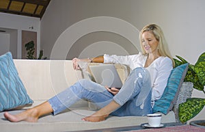 Beautiful and happy elegant blond woman early 40s relaxed at home living room using internet on laptop computer working comfortabl