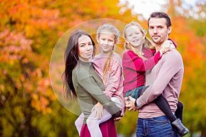 Beautiful happy family of four in autumn day outdoors