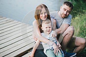 Beautiful happy family having picnic near lake