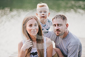 Beautiful happy family having picnic near lake