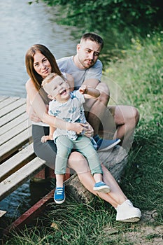 Beautiful happy family having picnic near lake