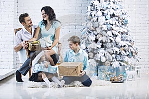 Beautiful happy family mother, father, son, and daughter to celebrate Christmas and new year together at home