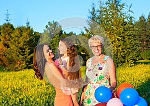 Beautiful happy family outdoors during sunset with balloons