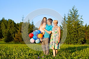 Beautiful happy family outdoors during sunset with balloons