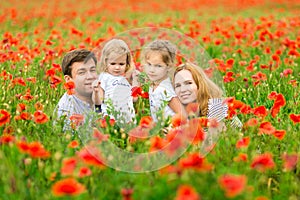 Beautiful happy family standing in poppy field