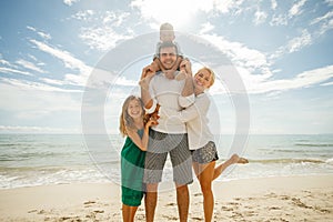 beautiful happy family on vacation standing together in front of ocean