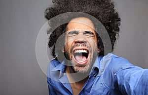 Beautiful happy funky afro man posing in front of a background