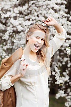 Beautiful happy girl in blossom garden on a spring day