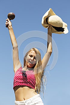 Beautiful happy girl hands up with maracas and hat half-length