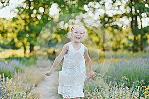 beautiful happy girl running in meadow. Beautiful warm summer evening. Little child in lavender field. Freedom, childhood,