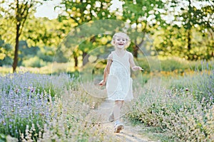 beautiful happy girl running in meadow. Beautiful warm summer evening. Little child in lavender field. Freedom, childhood,