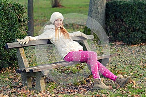 Beautiful happy girl sitting in autumn park