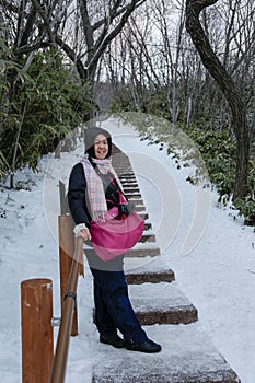 Beautiful and happy girl in winter snowy day outdoors