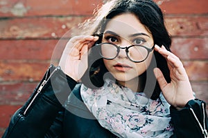 Beautiful happy hipster girl goes in the city. Closeup of trendy girl face.