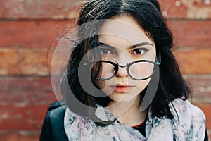 Beautiful happy hipster girl goes in the city. Closeup of trendy girl face.