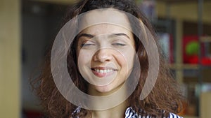 Beautiful happy hispanic young adult 20s woman looking at camera, headshot.