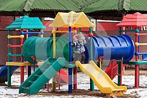 Beautiful happy kid on a winter playground outdoor