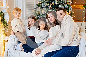 Beautiful happy large family on the couch by the Christmas tree.