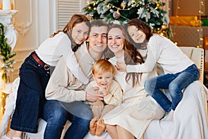 Beautiful happy large family on the couch by the Christmas tree.