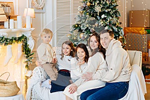 Beautiful happy large family on the couch by the Christmas tree.