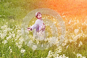 Beautiful happy middle-aged woman stands in a meadow with wildflowers