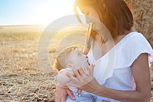 Beautiful happy mother breastfeeding her baby boy outdoor.