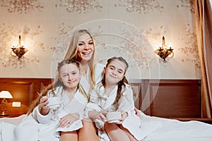 Beautiful and happy mother and her two daughters, embrace and la