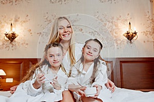 Beautiful and happy mother and her two daughters, embrace and la