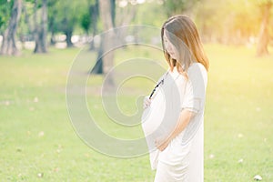 Beautiful and happy pregnant woman in the garden