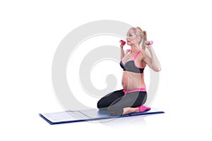 Beautiful happy pregnant women doing exercise with dumbbells on the white background