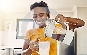 Beautiful, happy and relaxed woman making coffee and pouring hot beverage in cup for morning home kitchen routine. Young